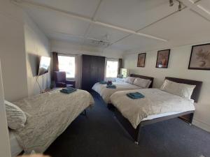 a bedroom with two beds and a chair in it at Royal Oak Rooms in Exeter