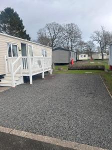 a mobile home with a porch and a driveway at Riverside 24 - Haggerston Castle in Berwick-Upon-Tweed