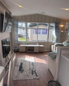 a living room with a couch and a table at Riverside 24 - Haggerston Castle in Berwick-Upon-Tweed