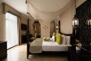 a bedroom with a large bed with yellow pillows at Villa Monticello Boutique Hotel in Accra