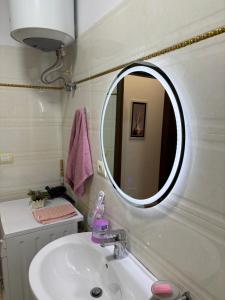 a bathroom with a sink and a mirror at Shtepi ditore elbasan in Elbasan +24 photos