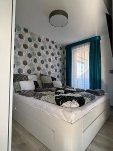 a bedroom with a large bed with blue curtains at Minimál Éden in Balatonlelle