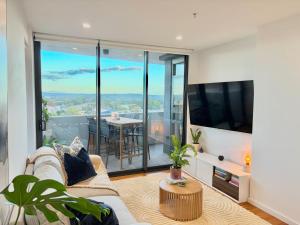 a living room with a couch and a large window at Harbour Towers Apartments, Free Parking & Tram Access - Hello Newcastle Accommodations in Newcastle