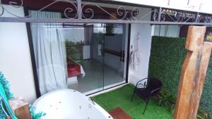 a screened in porch with a chair and a window at Pousada Marajoara - Pipa in Pipa