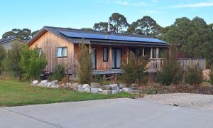 a house with a solar roof on top of it at Whare Aorere in Collingwood