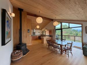 a kitchen and dining room with a table and chairs at Whare Aorere in Collingwood