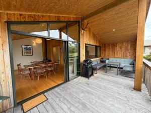 an open patio with a table and chairs on a deck at Whare Aorere in Collingwood +3 photos