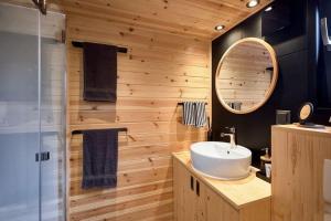 ein Badezimmer mit Waschbecken und Spiegel in der Unterkunft Tiny BlackandWood in Redu