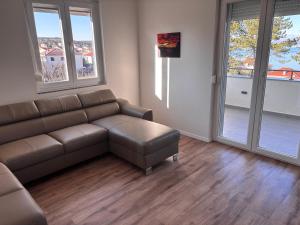 a living room with a brown couch and windows at Apartment Karmen in Šilo