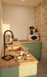 a kitchen with a sink and two cups on a counter at Almurigini I Boutique House I Ceglie Messapica in Ceglie Messapica +47 photos