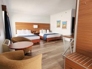 a hotel room with two beds and a table at Hotel L'Oie des neiges in Lévis +50 photos