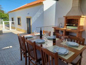 a wooden table with chairs and wine glasses on a patio at Casa Oliveira in Silves