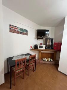 a living room with a table and chairs and a microwave at La Perla del Dolcedorme in San Lorenzo Bellizzi