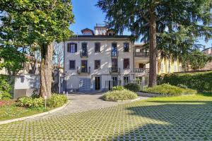 a large white building with trees in front of it at Attico Mansardato con terrazzo privato in Monza