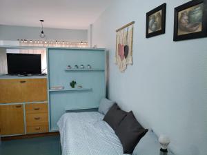 a bedroom with a bed and a dresser with a television at Magnolia Vintage in San Bernardo