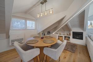 a dining room and living room with a table and chairs at Attico Mansardato con terrazzo privato in Monza