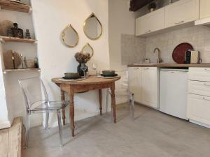 a kitchen with a wooden table and two mirrors at Mon nid sous les toits in L'Isle-sur-la-Sorgue +13 photos