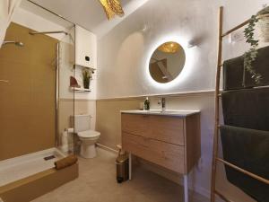 a bathroom with a sink and a toilet and a mirror at Mon nid sous les toits in L'Isle-sur-la-Sorgue