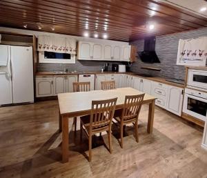 a kitchen with white cabinets and a wooden table and chairs at Nordic DeLight in Skelleftehamn