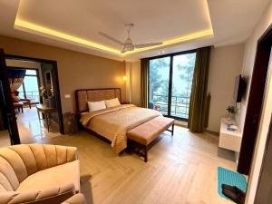 a bedroom with a bed and a couch and a television at Premium Murree Apartment With Stunning Views in Murree