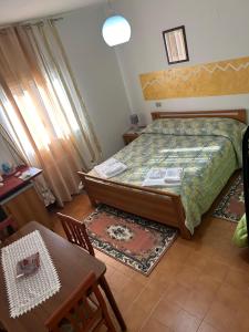 a bedroom with a bed and a table and chairs at La Perla del Dolcedorme in San Lorenzo Bellizzi