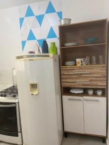 a small kitchen with a white refrigerator and a stove at Apto térreo, próx ao Centro, Sesi, Bioethicus, fácil acesso à Unesp in Botucatu +5 photos