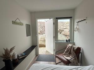 a bedroom with a bed and a chair and a window at Open Water Lodge Smögen in Smögen