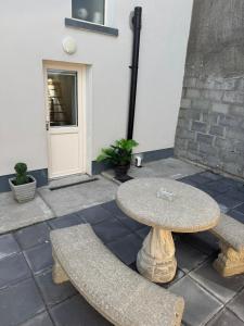 a stone table and bench in front of a building at Shrule Cosy Nest in Shruthair