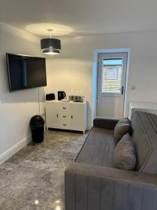 a living room with a couch and a flat screen tv at Shrule Cosy Nest in Shruthair
