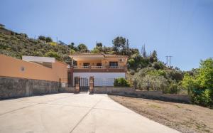 a large yellow house with a driveway at The Alma Suite in Alora