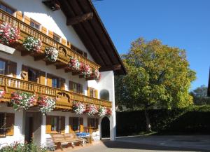 a building with flowers on the balconies and a bench at Kochhof in Piding