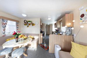 a kitchen and living room with a table in a caravan at 3 Bedroom Caravan, Edi Rita, Robin Hood, Pet Friendly in Meliden