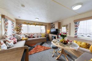 a living room with a couch and a table at 3 Bedroom Caravan, Edi Rita, Robin Hood, Pet Friendly in Meliden