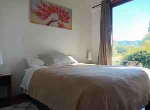 a bedroom with a bed and a large window at Cabaña la nonita, queule in Queule