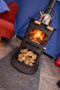 a wood fired oven with a tea kettle on top at Alpaca Hideaway in Llanstadwell