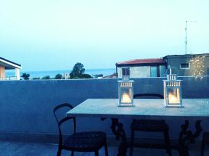 - une table sur un balcon éclairé dans l'établissement La casa di Teseo, à Cannizzaro