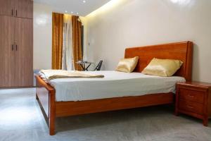 a bedroom with a large bed with a wooden headboard at Résidence Madior C3 in Dakar