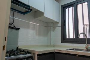 a kitchen with a sink and a stove and a window at Résidence Madior C3 in Dakar