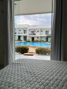 ein Schlafzimmer mit Bett und Blick auf einen Pool in der Unterkunft Flat Granito e Jasmim in Conde + 9 Fotos