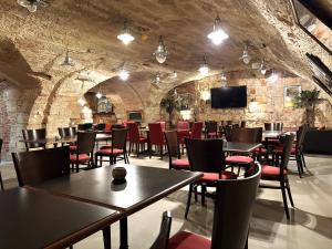 a dining room with tables and chairs and a tv at eXo Hotel Franka Bamberg - by NeVo Hotels in Hallstadt