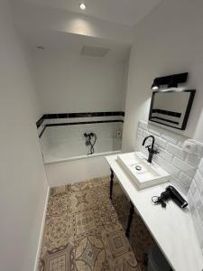 a white bathroom with a sink and a mirror at Saint Pierre Gîte in Ambleteuse