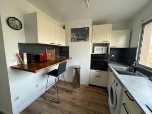 a kitchen with white cabinets and a counter top at appartement vincennes avec balcon in Vincennes