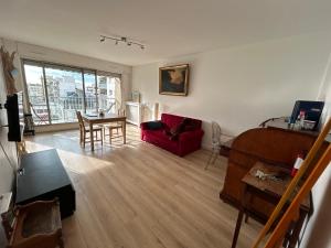 a living room with a red couch and a table at appartement vincennes avec balcon in Vincennes