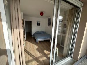 a bedroom with a bed in a room with a mirror at appartement vincennes avec balcon in Vincennes