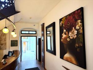 a hallway with a painting of a woman with flowers at eXo Hotel Franka Bamberg - by NeVo Hotels in Hallstadt +59 photos