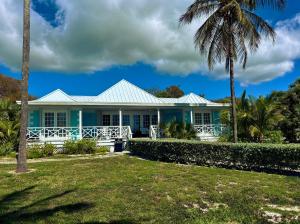a blue house with a palm tree at The Blue Inn Family Vacation Rental in Smith Point