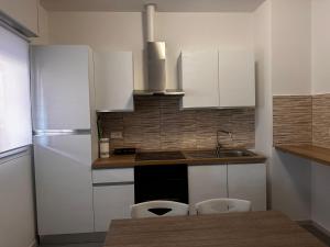 a kitchen with white cabinets and a sink and a refrigerator at sweet rest in Castel Maggiore +8 photos