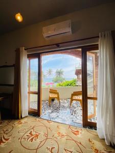 a room with a large glass door with a view at Lushy Glorious Hotel in Matara