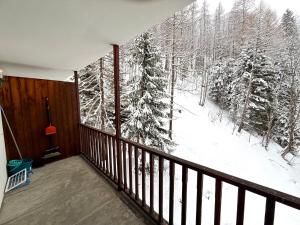 ein Balkon mit Blick auf einen schneebedeckten Wald in der Unterkunft Piccolo Bric in Ghigo