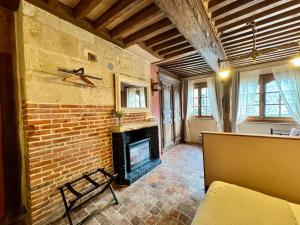 a living room with a brick fireplace and a couch at Le 16 authentique au cœur de la ville in Lisieux